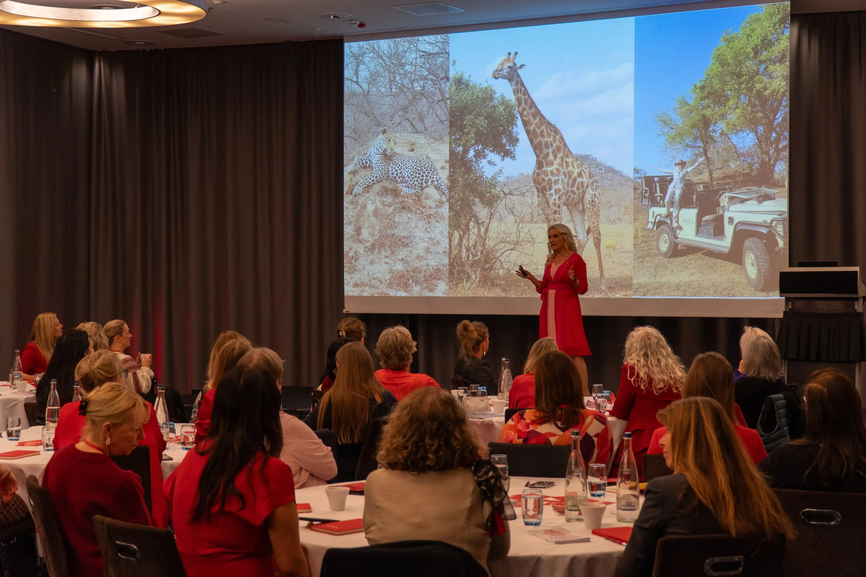 Sigrun speaking on stage at SIGRUN Live 2025, the room in front of her